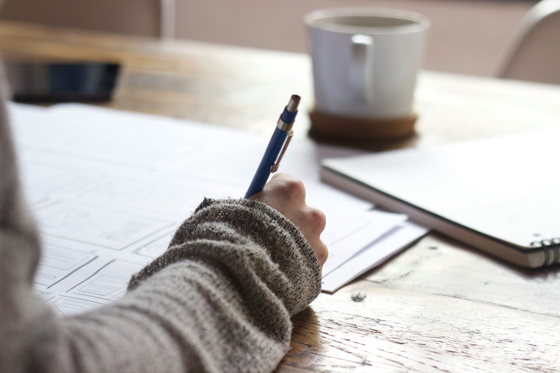 person writing a note at table